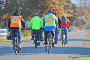 Safety first - group of cyclists wearing reflective jackets and helmets