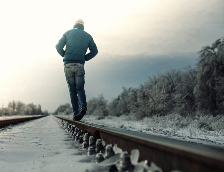 meditate on thought - man walking along train tracks in winter